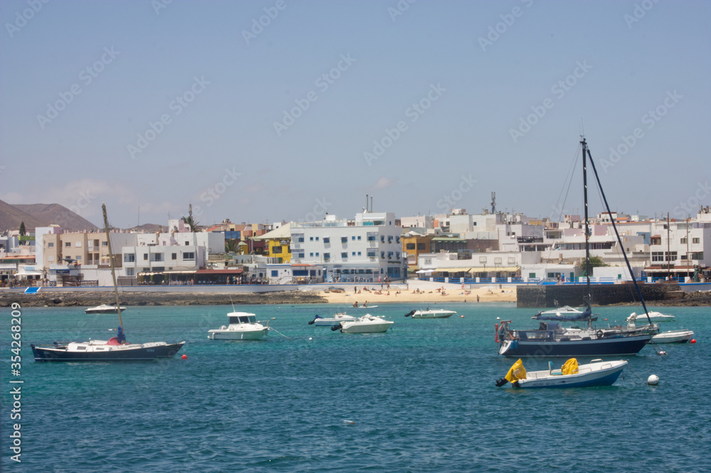 Corralejo Fuertaventura, Spain from the Harbor. Blue sea and sky with boats mored. Space left for copy text