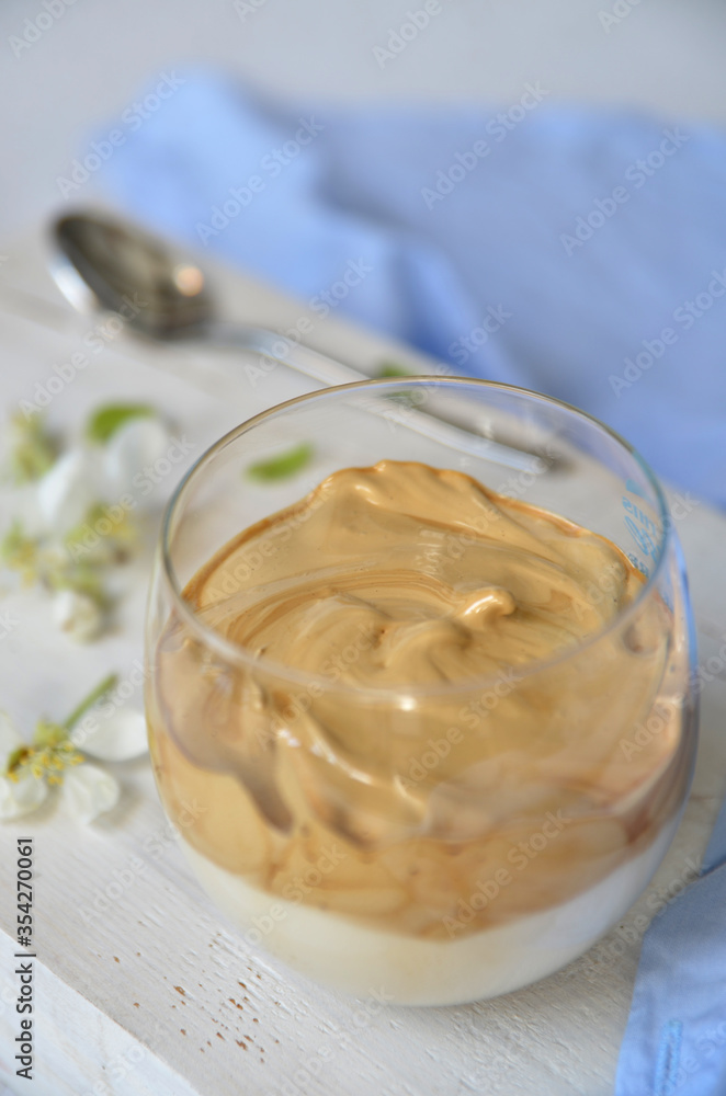 Dalgona coffee in a glass on a light wooden background Dalgona coffee in a glass on a light wooden background