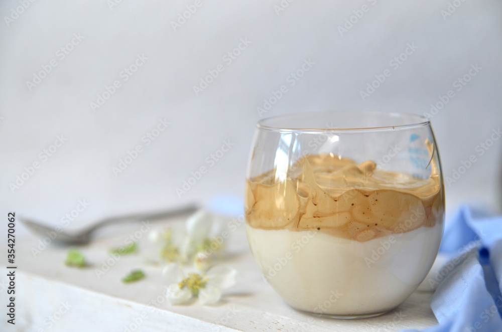 Korean coffee called Dalgona coffee in a glass on a light wooden background Korean coffee called Dalgona coffee in a glass on a light wooden background