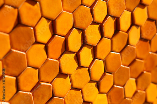 Bright orange sunlit hexagonal honeycomb tile background 