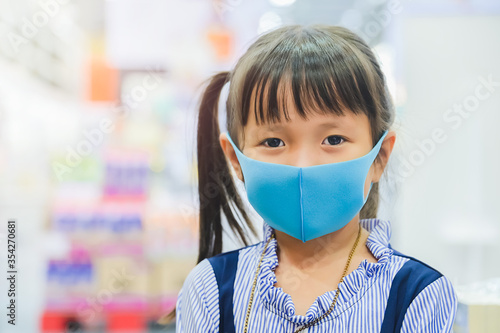 Little girl has fabric mask protect herself from Coronavirus,New Normal lifestyle after COVID-19 outbreak child leave the house with mask on nose for safety outdoor activity,illness or Air pollution