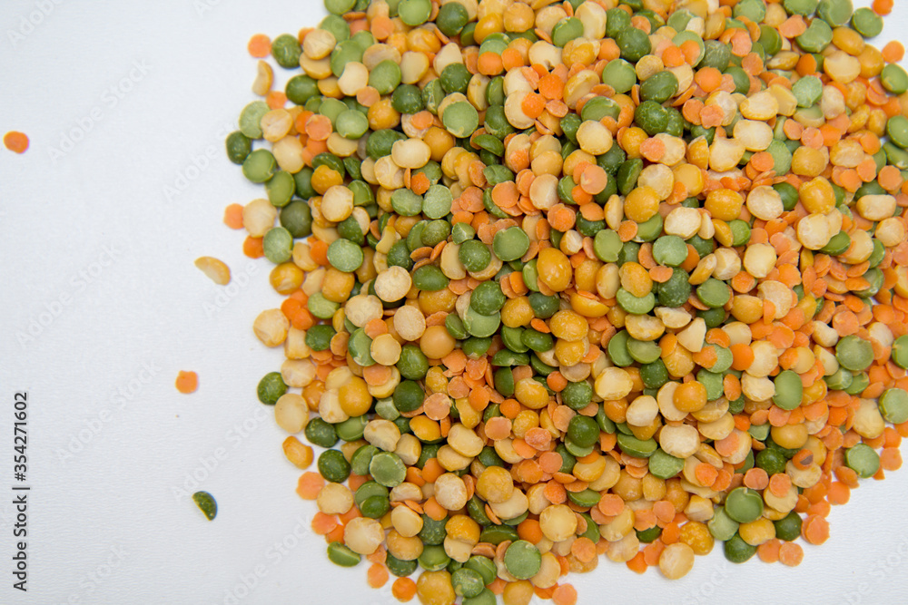 Background-multicolored varieties of legumes are scattered on a white background. Concept of raw food and healthy nutrition. Background-multicolored varieties of legumes are scattered on a white background. Concept of raw food and healthy nutrition.