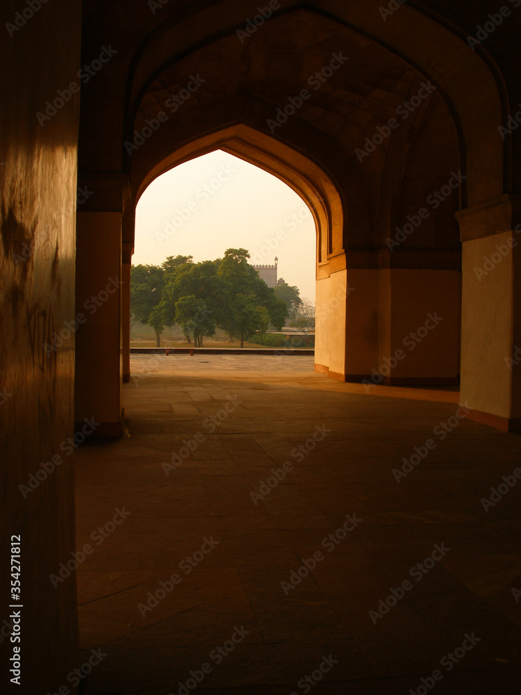  dark corridor and light arch of Red Fort, India, beautiful garden trees and lawns	 