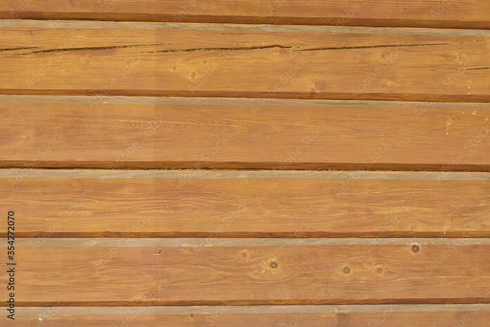 The wall is wooden. The tree is painted brown. The wall is wooden. The tree is painted brown.