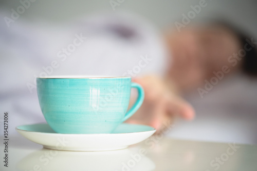 Woman is drinking a morning coffee from a cup close up.