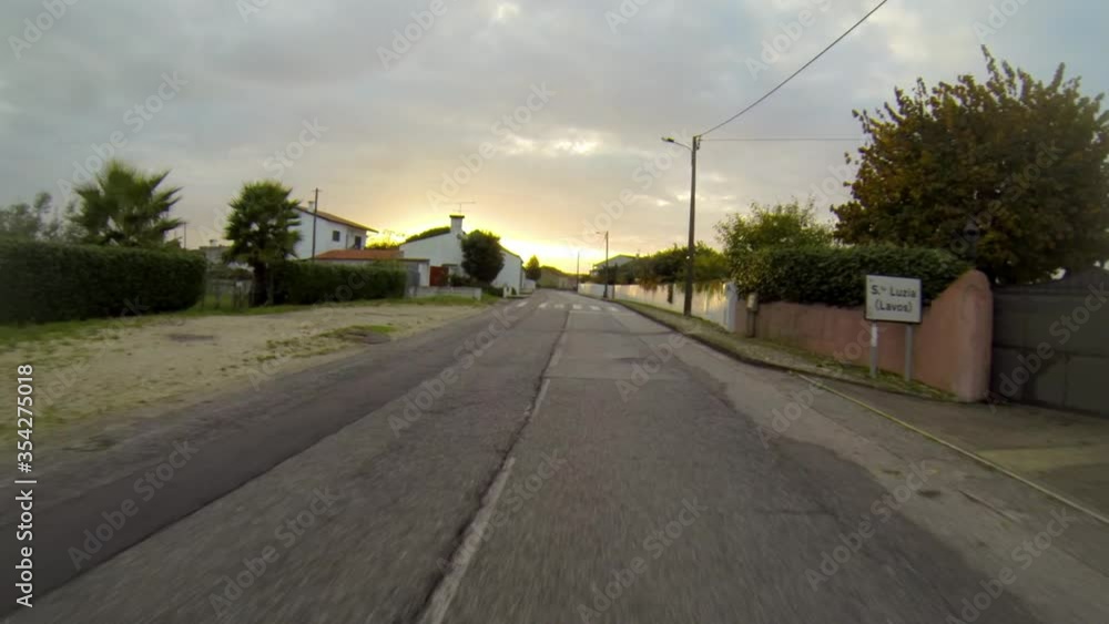 POV shot of road amidst houses against sky during sunset - Figueira da Foz, Portugal POV shot of road amidst houses against sky during sunset - Figueira da Foz, Portugal