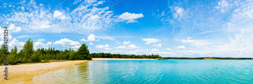 Panorama of a swimming lake with turquoise water on a wonderful day in summer