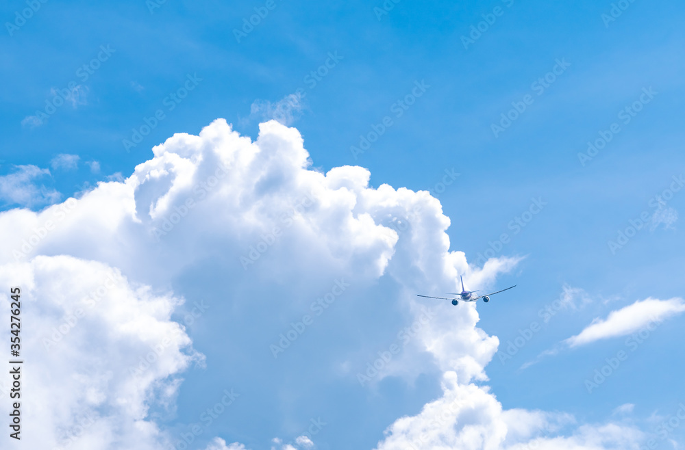Commercial airline flying on blue sky and white fluffy clouds. Airplane flying on sunny day. Rear view of international flight passenger plane. Summer vacation travel abroad. Air transportation. Commercial airline flying on blue sky and white fluffy clouds. Airplane flying on sunny day. Rear view of international flight passenger plane. Summer vacation travel abroad. Air transportation.