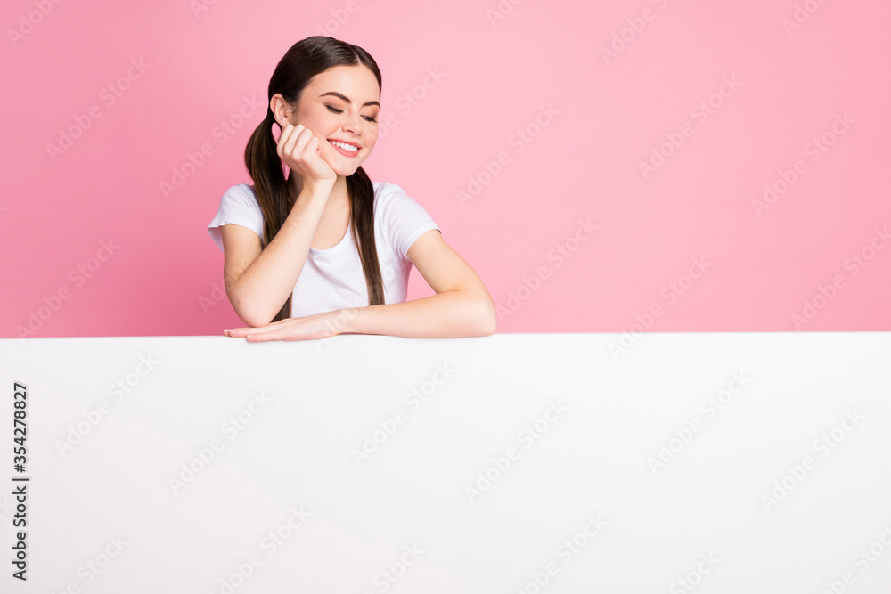 Photo of cheerful pretty lady leaning hands on big empty paper poster read interesting advertisement sale shopping wear casual white t-shirt isolated pastel pink color background Photo of cheerful pretty lady leaning hands on big empty paper poster read interesting advertisement sale shopping wear casual white t-shirt isolated pastel pink color background