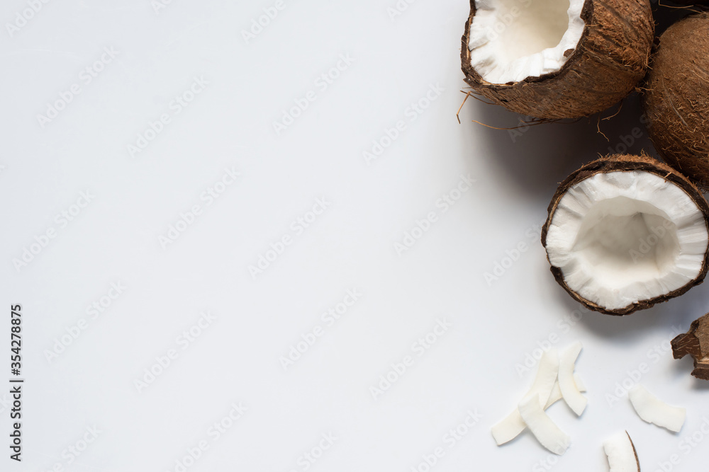 top view of fresh tasty coconut halves and flakes on white background top view of fresh tasty coconut halves and flakes on white background