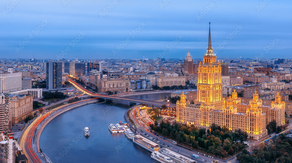 Obraz premium View of the city from a height. Moscow landmark. Hotel and Flotilla Radisson Royal. Novy Arbat, Moscow river and ships. City traffic, evening illumination.