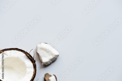 top view of cracked tasty coconut half and pieces on white background