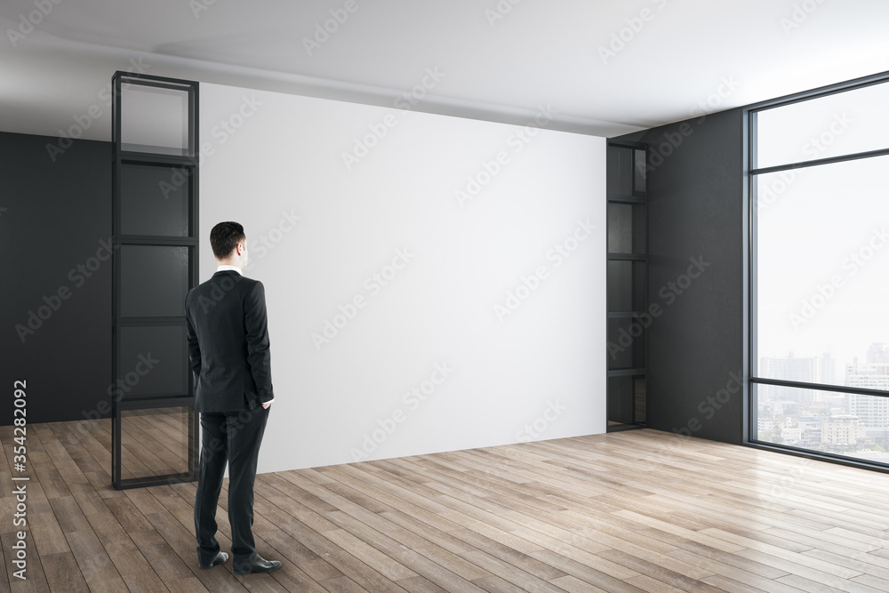 Businessman standing in modern gallery room.