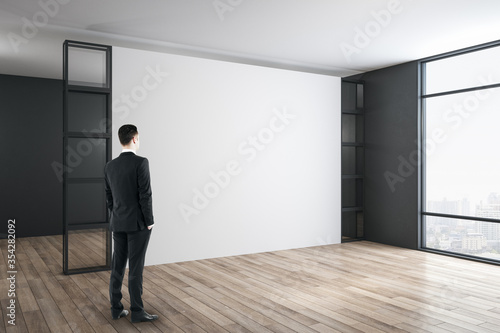 Businessman standing in modern gallery room.