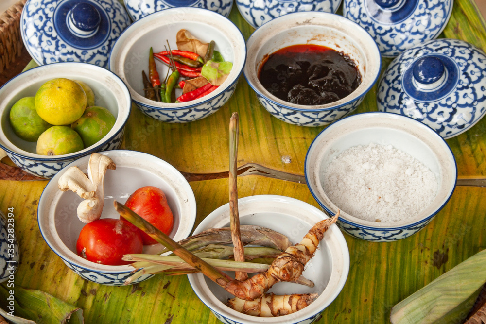 Ingredients of traditional Thai spicy soup Tom Yum Kung in typical blue asian bowls