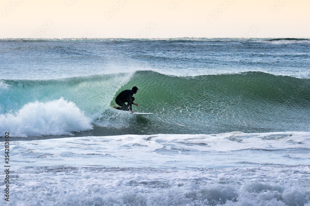 Japan surfing , sometimes during a typhoon, there are many waves in Japan especially in Hebara, Katsuura, Chiba. Westerner surfs large waves. Sunrise & at the beach with a surfer & his surf board. Japan surfing , sometimes during a typhoon, there are many waves in Japan especially in Hebara, Katsuura, Chiba. Westerner surfs large waves. Sunrise & at the beach with a surfer & his surf board.