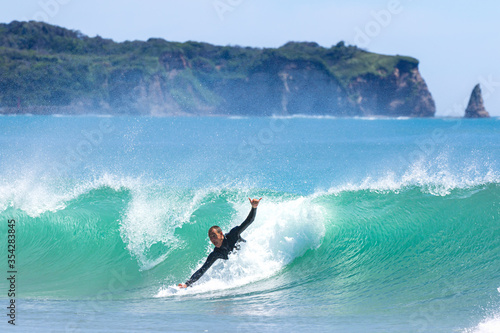 Japan surfing , sometimes during a typhoon, there are many waves in Japan especially in Hebara, Katsuura, Chiba. Westerner surfs large waves. Sunrise & at the beach with a surfer & his surf board. photo