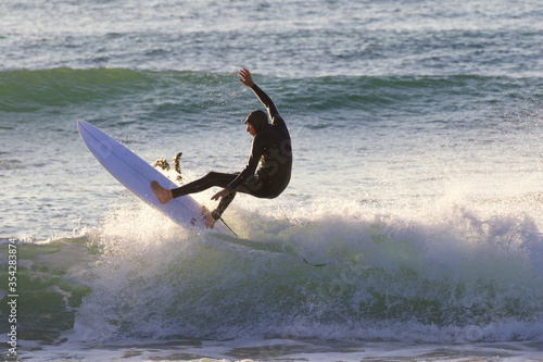 Japan surfing , sometimes during a typhoon, there are many waves in Japan especially in Hebara, Katsuura, Chiba. Westerner surfs large waves. Sunrise & at the beach with a surfer & his surf board. photo