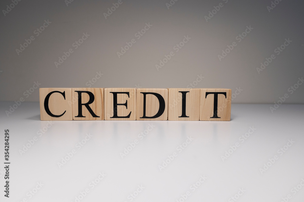 The word credit from wooden blocks. Business and banking concept. Spot light on white background. Close up. The word credit from wooden blocks. Business and banking concept. Spot light on white background. Close up.