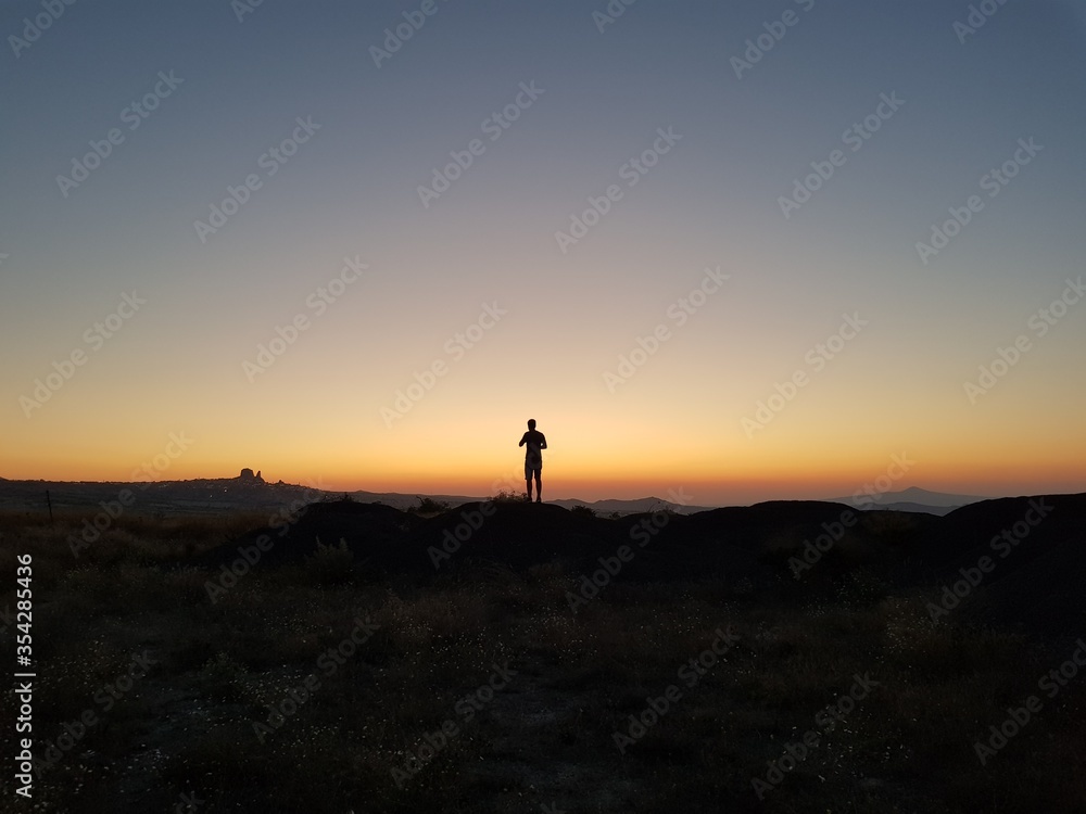 Silhouette of a man standing on a hill on the sunset, Silhouette of a man on the sunset, Cappadocia, Kapadokya, Turkey, Uchisar Castle in Cappadocia Region of Turkey, Sunset, National Geographic