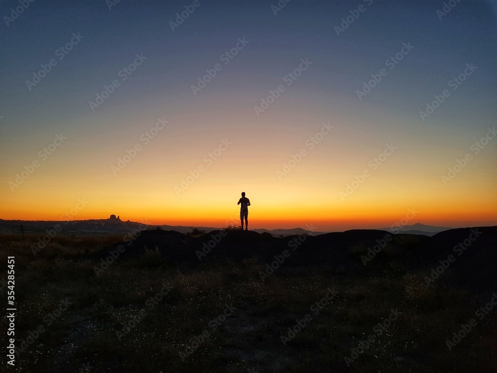 Silhouette of a man standing on a hill, Silhouette of a man on the sunset, Cappadocia, Kapadokya, Turkey, Uchisar Castle in Cappadocia Region of Turkey, Sunset, National Geographic