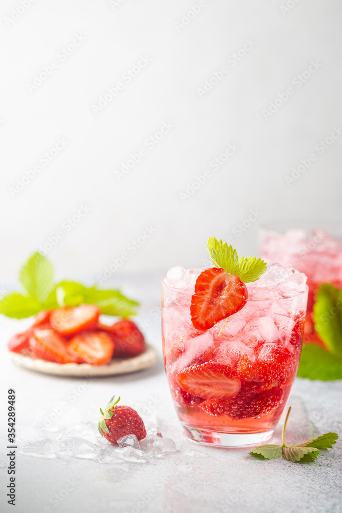 Refreshing summer drink with strawberry slices in glasses on white background Refreshing summer drink with strawberry slices in glasses on white background