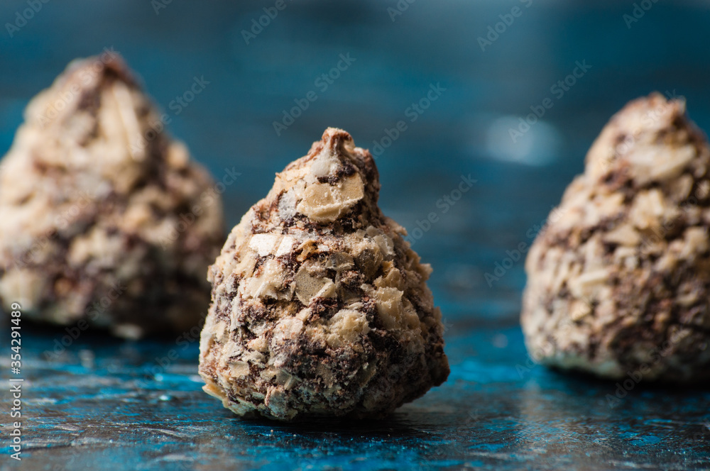 Chocolate candies in waffle chips close-up macro on blue background Chocolate candies in waffle chips close-up macro on blue background