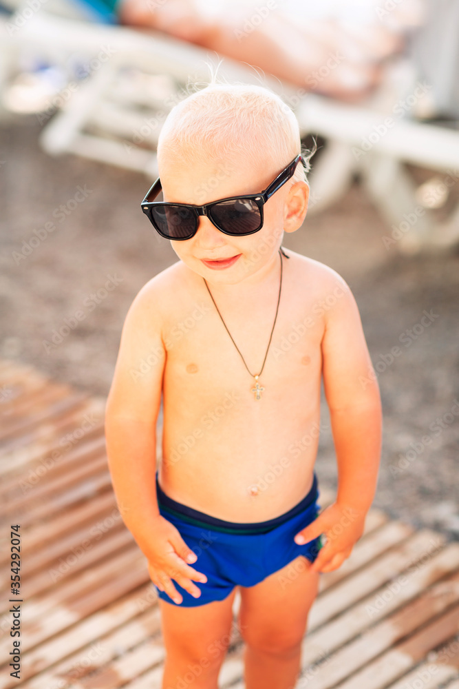 Cute baby boy wearing sunglasses on the beach Cute baby boy wearing sunglasses on the beach