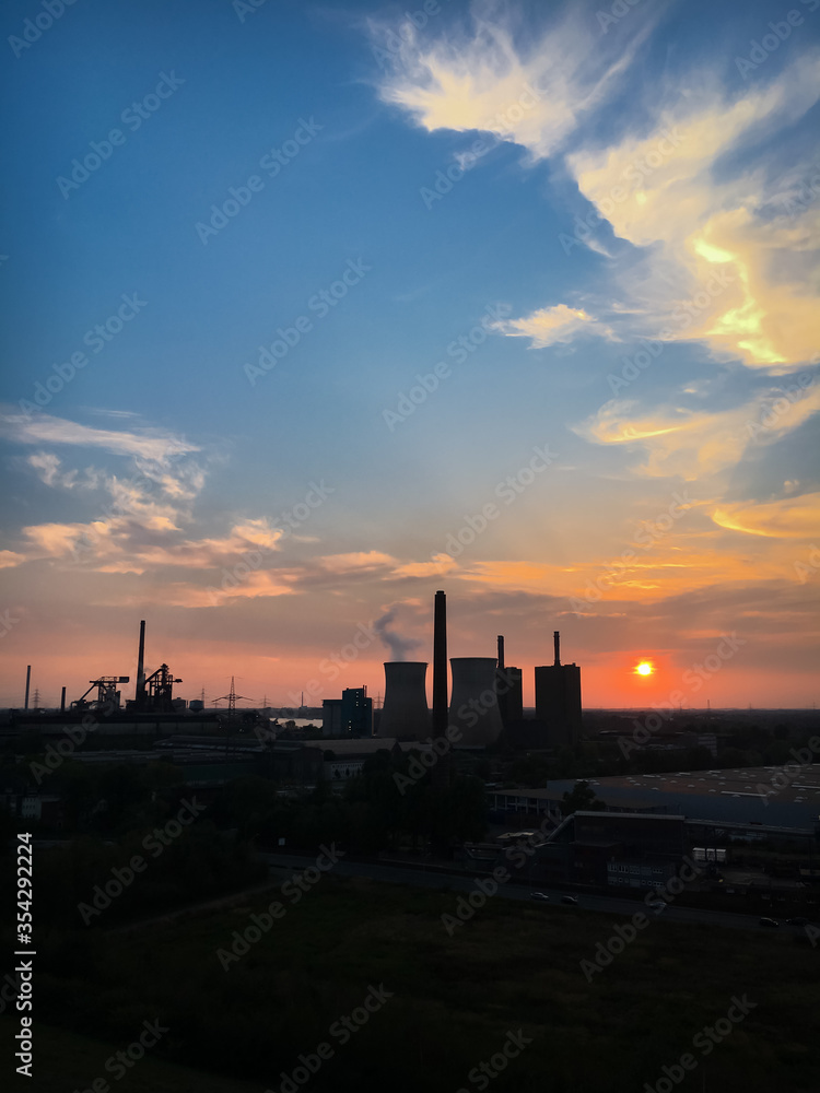 Scenic view of power station and cooling tower at sunset against sky. Scenic view of power station and cooling tower at sunset against sky.