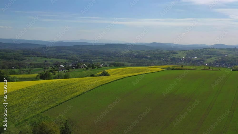 Aerial View Of Broad Farmland With Various Crops Hills And Village In Background. Aerial View Of Broad Farmland With Various Crops Hills And Village In Background.