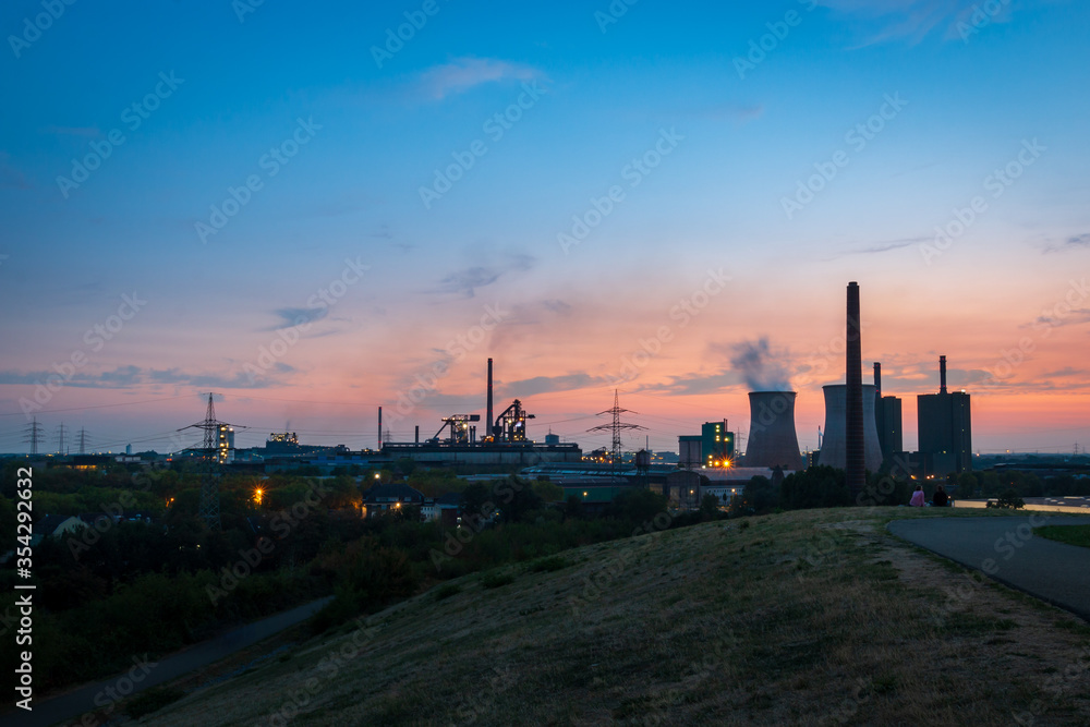 Scenic view of industrial landscape power station and cooling tower at sunset against sky. Scenic view of industrial landscape power station and cooling tower at sunset against sky.