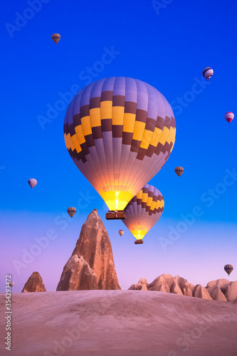 Hot air balloons taking off at sunrise. It is a nice activity for tourists who want to see the historical points and fairy chimneys of Cappadocia from the air every morning.