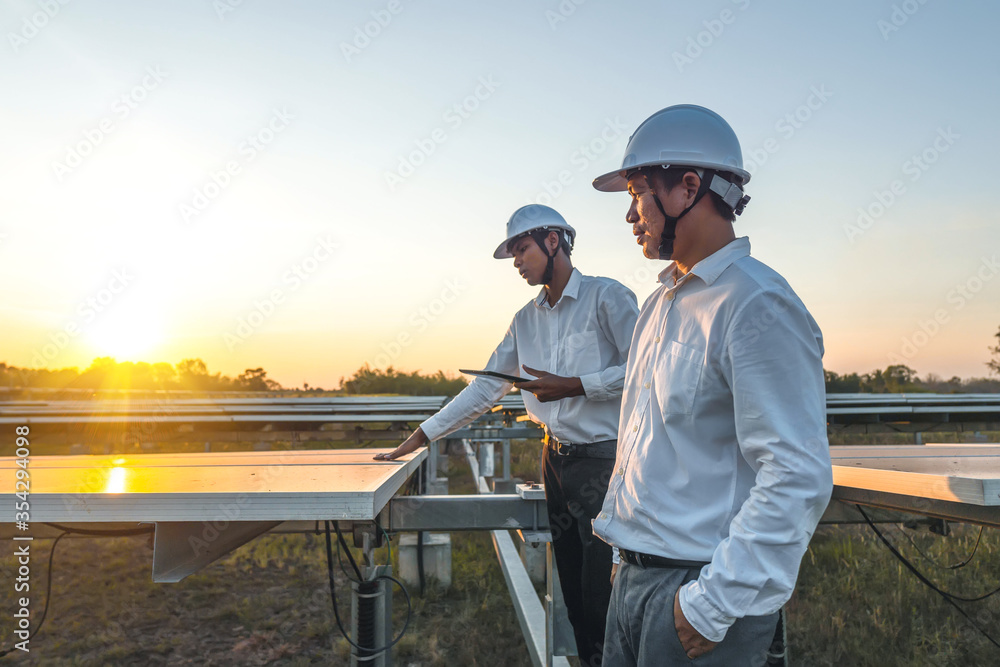 The solar farm(solar panel) with two engineers walk to check the operation of the system, Alternative energy to conserve the world's energy, Photovoltaic module idea for clean energy production