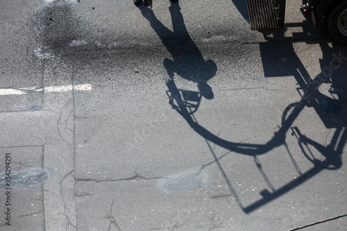 Road restoration work. The shadow of worker which performs on road patcher work on the repair of cracks by filling and sealing with coated by bitumen emulsion and dry aggregate in the asphalt surface. photo