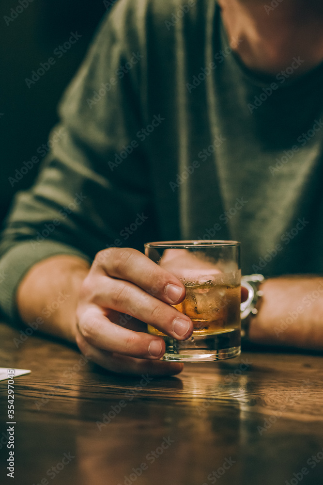 guy drinks whiskey with ice at the bar guy drinks whiskey with ice at the bar