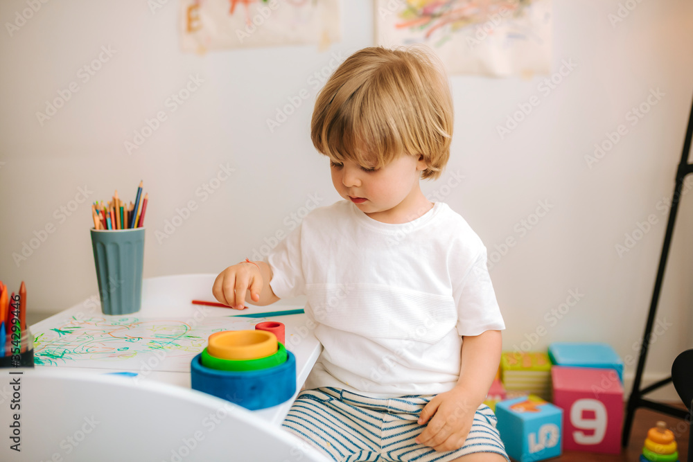 Little blond boy plays painting at home. entertainment during quarantine. family at home Little blond boy plays painting at home. entertainment during quarantine. family at home