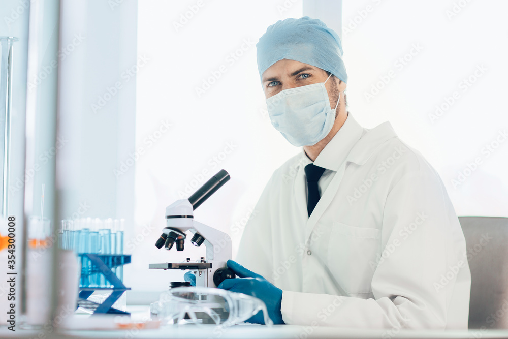 close up. scientist looking into the eyepiece of a microscope. close up. scientist looking into the eyepiece of a microscope.