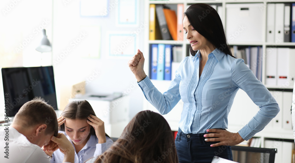 Serious brunette businesswoman training her young team Serious brunette businesswoman training her young team