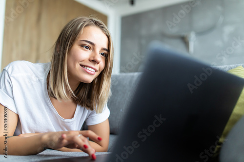 Portrait of beautiful young woman using laptop on sofa