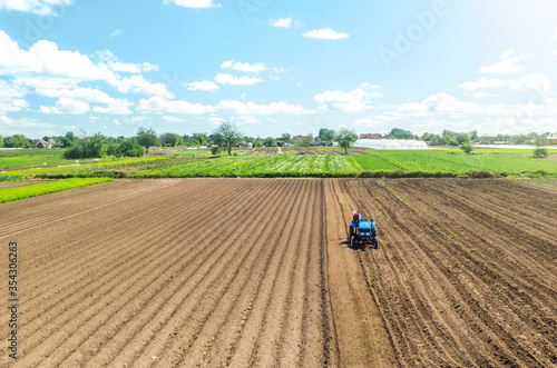 Farmer on tractor loosens and grinds the soil. Preparing the land for a new crop planting. Loosening the surface  cultivating the land. Farming and agriculture. agricultural sector of the economy.
