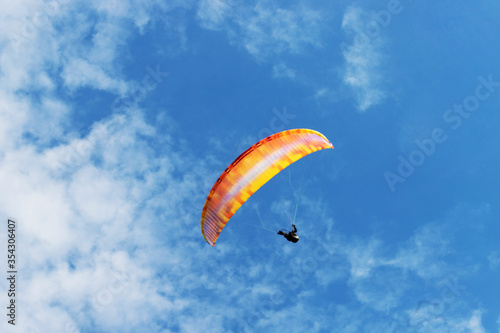 paraglider in a blue cloudy sky