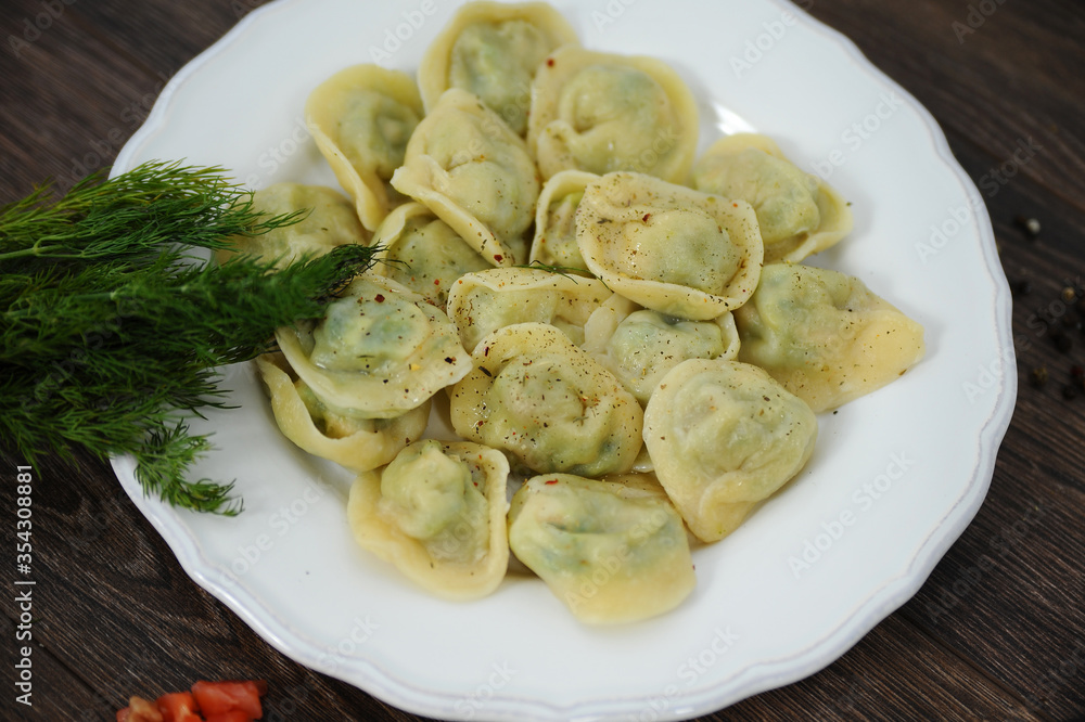 Dumplings on a wooden table with herbs tomatoes Dumplings on a wooden table with herbs tomatoes