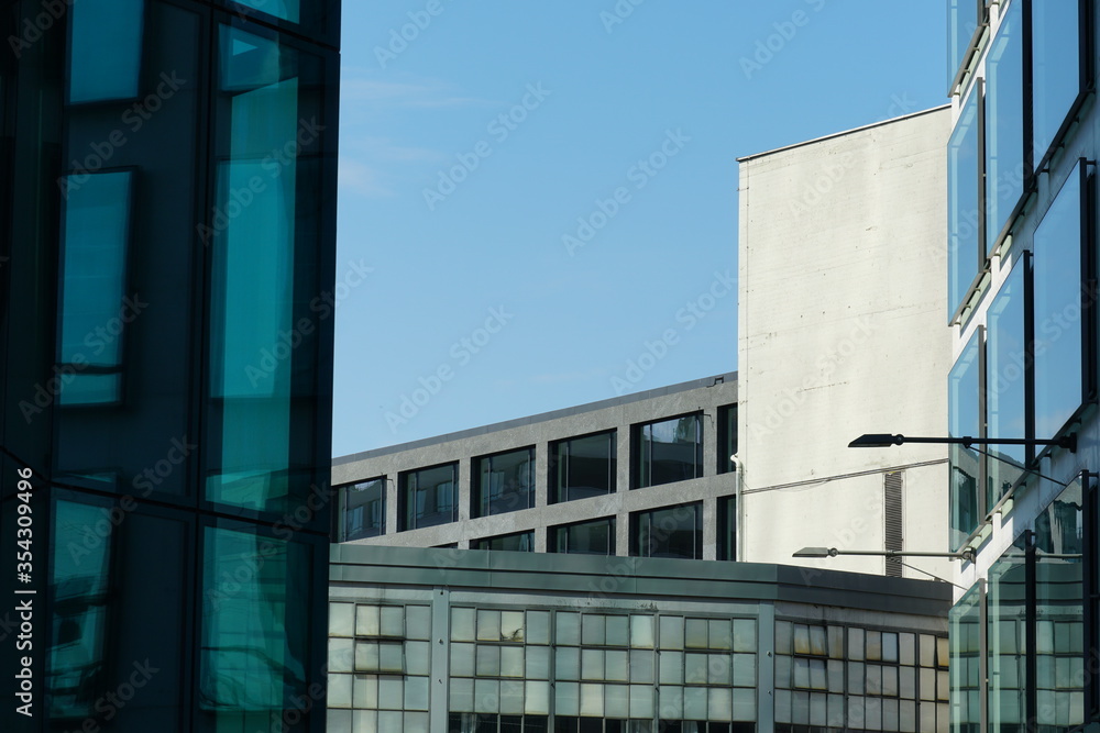 Obraz premium a scene from a business space, several corporate buildings standing near to each other with their facades of glass, marble, chrome and concrete, closed due to lockdown of coronavirus, covid-19