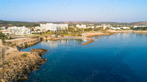 Aerial bird's eye view of Green bay in Protaras, Paralimni, Famagusta, Cyprus. Famous tourist attraction diving location rocky beach with boats, sunbeds, sea restaurants, water sports from above. © f8grapher