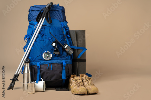 Fototapeta Blue backpack and hiking boots. Mountain gear close up