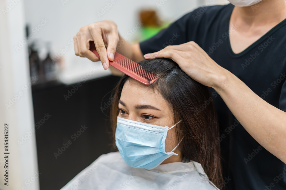 hairdresser cutting the hair to female client, people must be wering medical mask to protection coronavirus (covid-19) pandemic. new normal concepts hairdresser cutting the hair to female client, people must be wering medical mask to protection coronavirus (covid-19) pandemic. new normal concepts