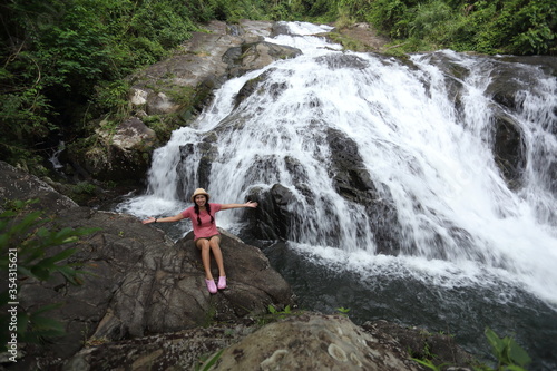 Woman sitting on the rocks at Khao Soi Dao waterfall in Chanthaburi, Thailand