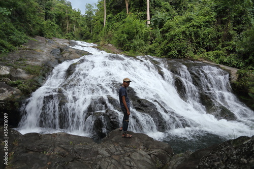 Man standing on the rocks at Khao Soi Dao waterfall in Chanthaburi, Thailand