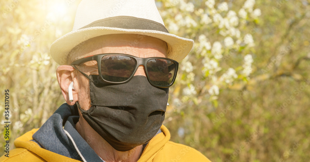 aged man in wireless headphones and disposable mask closeup aged man in wireless headphones and disposable mask closeup