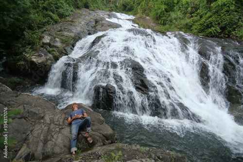 man lying on the rocks at Khao Soi Dao waterfall in Chanthaburi, Thailand